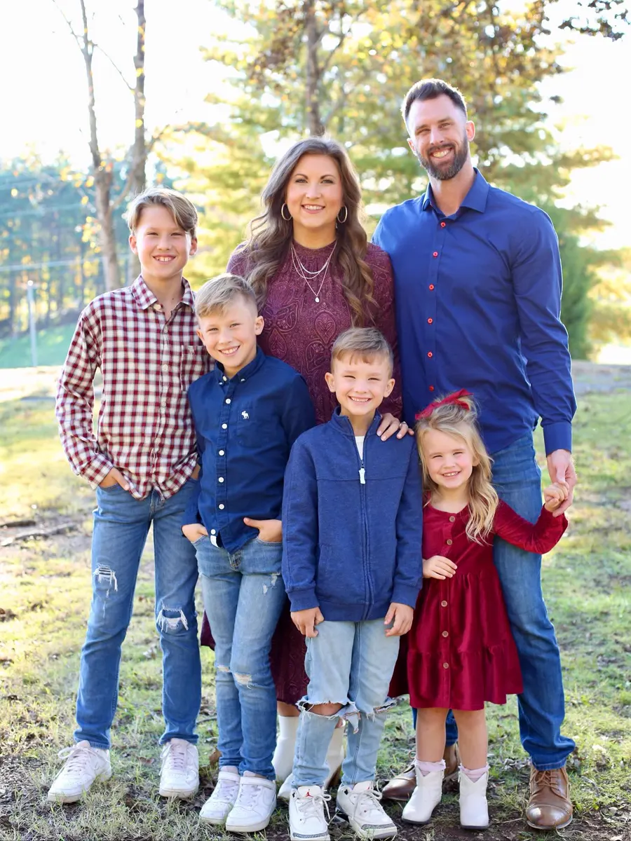 Aaron with his wife and kids outside on a winter afternoon.